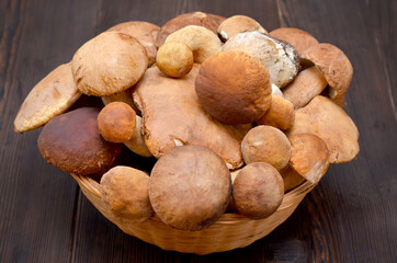 basket with porcini mushrooms on a dark wooden background close-up