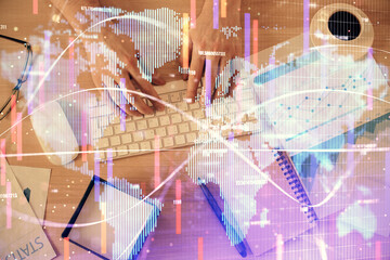 Double exposure of man's hands typing over computer keyboard and business theme hologram drawing. Top view. Financial markets concept.