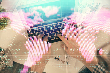 Double exposure of man's hands typing over computer keyboard and business theme hologram drawing. Top view. Financial markets concept.