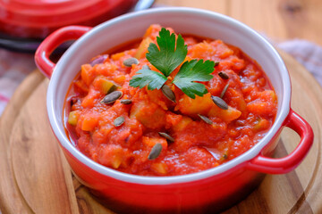 Vegetable stew in a beautiful red saucepan.