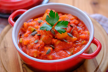 Vegetable stew in a beautiful red saucepan.