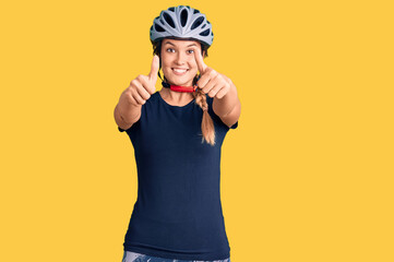 Beautiful caucasian woman wearing bike helmet approving doing positive gesture with hand, thumbs up smiling and happy for success. winner gesture.