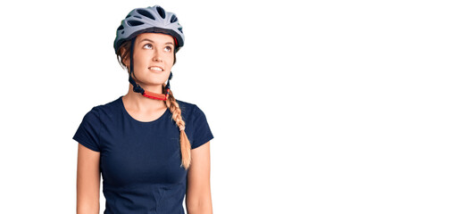 Beautiful caucasian woman wearing bike helmet looking away to side with smile on face, natural expression. laughing confident.