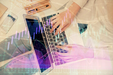 Double exposure of woman hands working on computer and forex graph hologram drawing. Top View. Financial analysis concept.