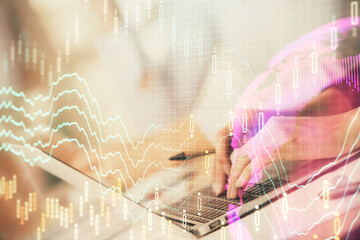 Double exposure of woman hands typing on computer and forex chart hologram drawing. Stock market invest concept.