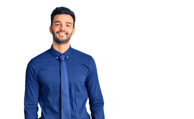 Fototapeta premium Young handsome hispanic man wearing business clothes looking positive and happy standing and smiling with a confident smile showing teeth