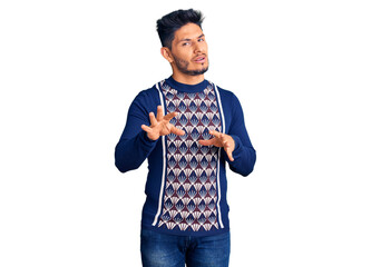 Handsome latin american young man wearing casual winter sweater disgusted expression, displeased...