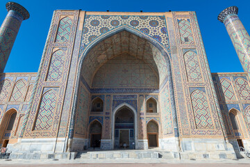 Fototapeta na wymiar Ulugh Beg Madrasah and its two minarets with ceramic tiles in Persian style. Registan, Samarkand, Uzbekistan. Islamic architecture.