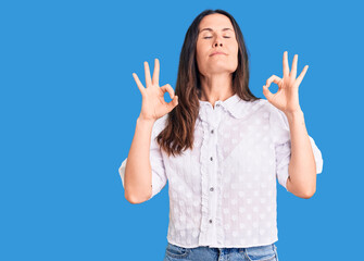 Young beautiful brunette woman wearing casual shirt relax and smiling with eyes closed doing meditation gesture with fingers. yoga concept.