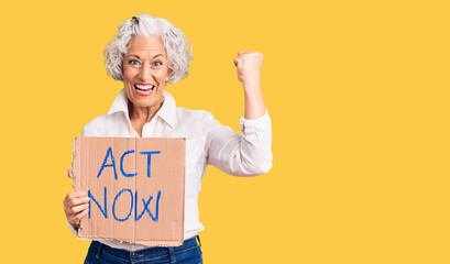 Senior grey-haired woman holding act now banner screaming proud, celebrating victory and success very excited with raised arms
