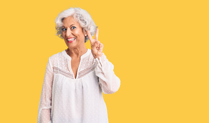 Senior grey-haired woman wearing casual clothes showing and pointing up with fingers number two while smiling confident and happy.