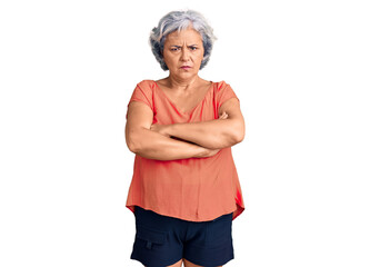 Senior woman with gray hair wearing orange tshirt skeptic and nervous, disapproving expression on face with crossed arms. negative person.