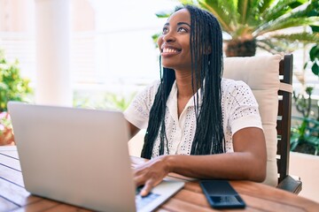 Young african american woman smiling happy working using laptop at terrace