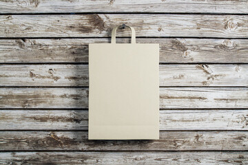 One paper shopping bag on wooden wall background.