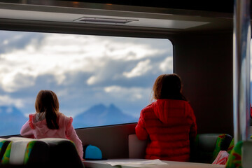 Two girls contemplate the landscape of the Beagle Channel through the window of a ferry boat during...