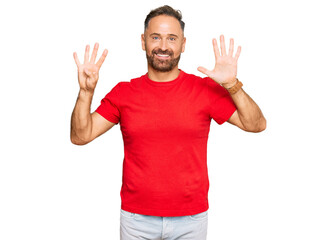 Handsome middle age man wearing casual red tshirt showing and pointing up with fingers number nine while smiling confident and happy.