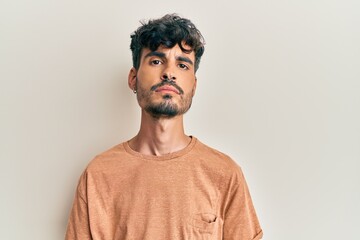 Fototapeta premium Young hispanic man wearing casual clothes relaxed with serious expression on face. simple and natural looking at the camera.