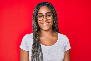 Young african american woman with braids wearing casual clothes and glasses with a happy and cool...