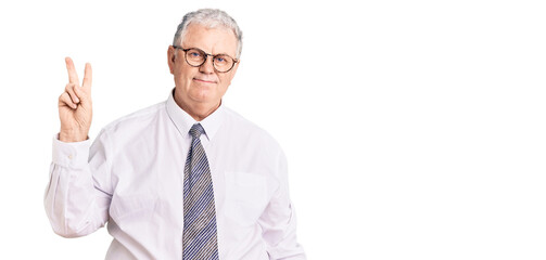 Senior grey-haired man wearing business clothes showing and pointing up with fingers number two while smiling confident and happy.