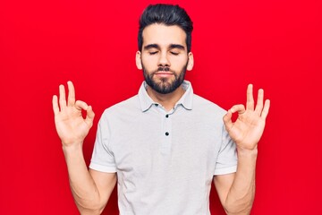 Young handsome man with beard wearing casual polo relax and smiling with eyes closed doing meditation gesture with fingers. yoga concept.