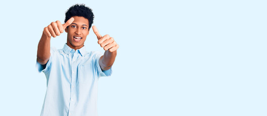 Young african american man wearing casual clothes approving doing positive gesture with hand, thumbs up smiling and happy for success. winner gesture.