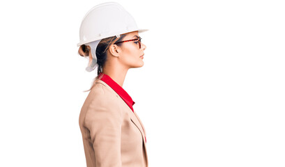 Young beautiful woman wearing architect hardhat looking to side, relax profile pose with natural...