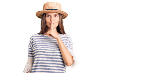 Beautiful caucasian woman wearing summer hat asking to be quiet with finger on lips. silence and secret concept.