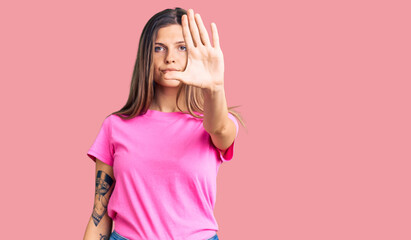Beautiful caucasian woman wearing casual clothes doing stop sing with palm of the hand. warning...