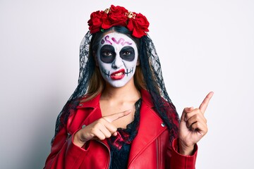Woman wearing day of the dead costume pointing with fingers to the side clueless and confused expression. doubt concept.