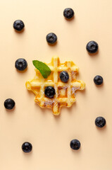 Sweet tasty waffles and berries on colored background