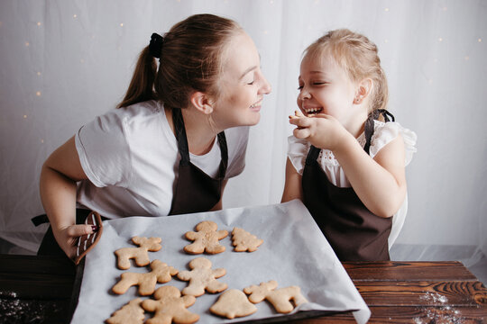 Mother and daughter eating gingerbread cookies