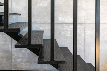 Loft minimal interior with metallic staircase on the background of gray cement wall. - Powered by Adobe