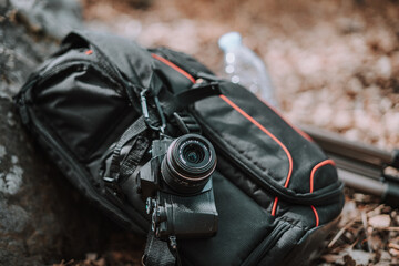 Equipo fotografico camara colgada de grillete de montaña en una mochila durante una expedicion de exploracion hacia una ruta verde en el sur de españa