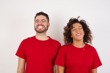Fototapeta premium Young beautiful couple wearing red t-shirt on white background very happy and excited about new plans.