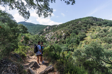 Fototapeta premium Dos chicos mirando el paisaje y señalando una montaña