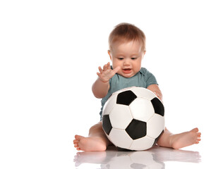 Little kid boy playing a new soccer ball on a white background.