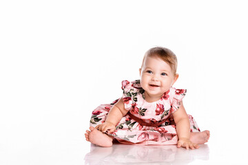 Pretty baby in beautiful dress sitting on floor