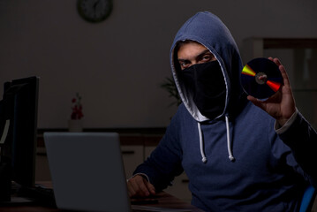 Male hacker hacking security firewall late in office