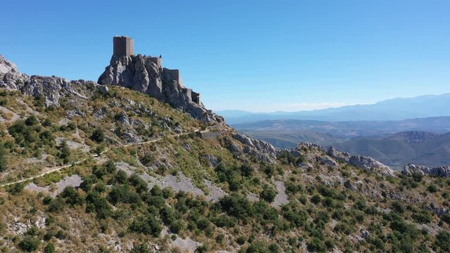 Aerial view of stone ruins of ancient fortified Chateau de Queribus on rocky hilltop on sunny summer day, Aude departement, France