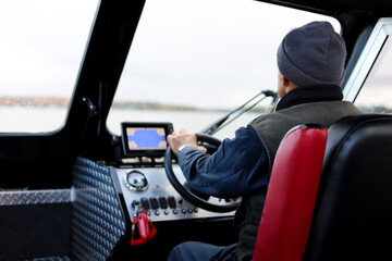 Man driving the yacht inside. Captain