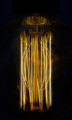 Close-up of a glowing incandescent light bulb filaments