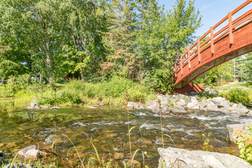 Fototapeta na wymiar Foot bridge over a flowing river landscape
