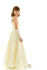 Fototapeta na wymiar A little girl in a long, elegant dress of a princess.