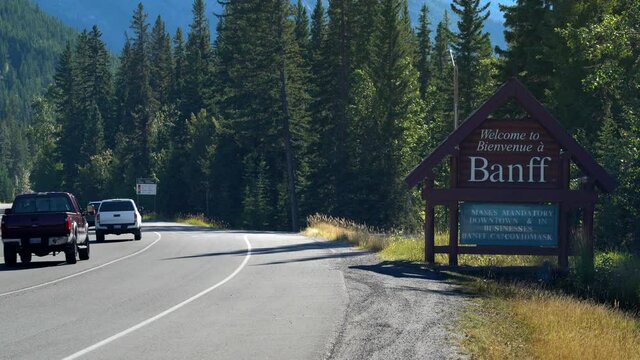 Establishing shot showing welcome sign with mask wearing advisory due to Covid-19 pandemic at the entrance of Banff town in Alberta, Canada.
