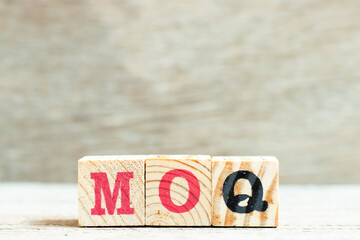 Alphabet letter block in word MOQ (Abbreviation of Minimum Order Quantity) on wood background