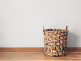 Wicker basket on floor near light wall