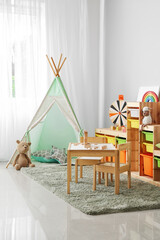 Interior of modern children's room with play tent and toys
