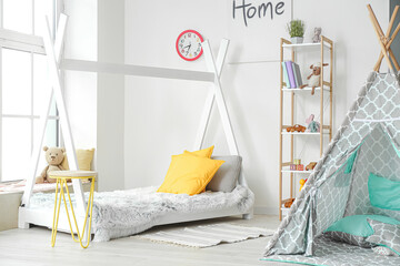 Interior of modern children's room with play tent and bed