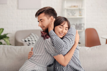 Happy couple hugging after quarrel at home - obrazy, fototapety, plakaty