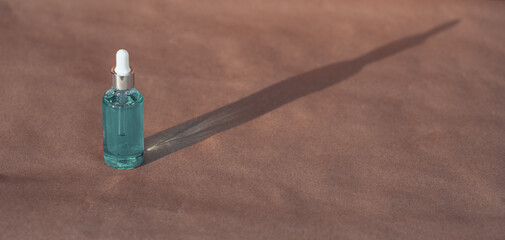 Naklejka premium Organic Spa Cosmetic With Herbal Ingredients. Vegetable serum for skin. Serum with herbal extracts. Serum in a transparent glass bottle with a pipette on a kraft background